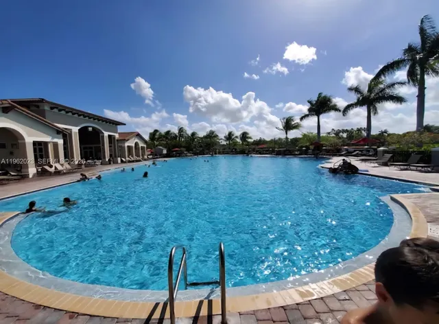 a view of a lake with a yard and palm trees