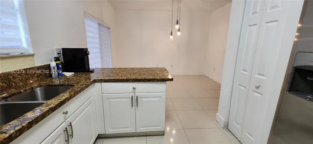 a kitchen with granite countertop white cabinets and stainless steel appliances