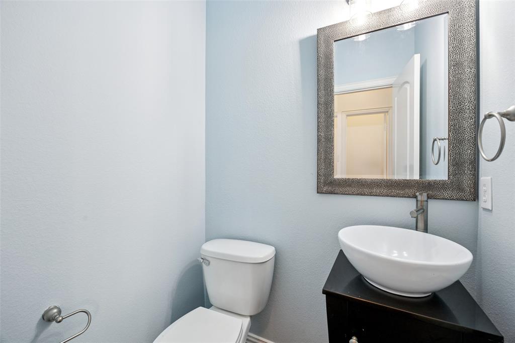 1503 Biltmore Lane Irving, TX 75063 - Photo 12 of 34 a bathroom with a toilet a sink and mirror