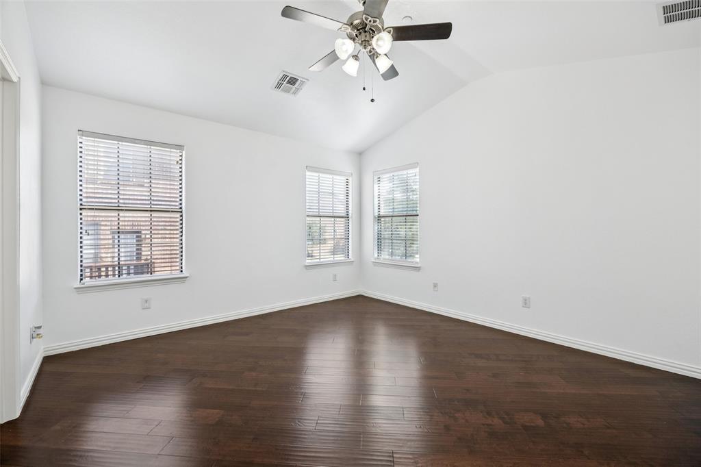 1503 Biltmore Lane Irving, TX 75063 - Photo 17 of 34 an empty room with wooden floor chandelier fan and windows