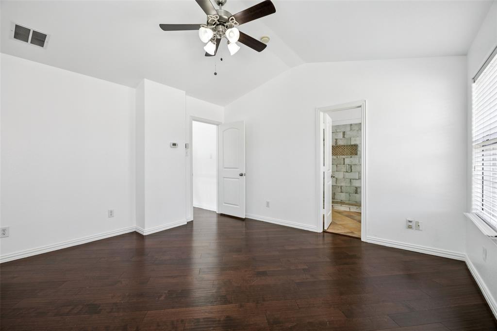 1503 Biltmore Lane Irving, TX 75063 - Photo 19 of 34 an empty room with wooden floor chandelier fan and windows