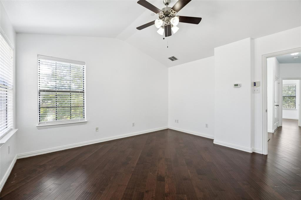 1503 Biltmore Lane Irving, TX 75063 - Photo 20 of 34 an empty room with wooden floor fan and windows