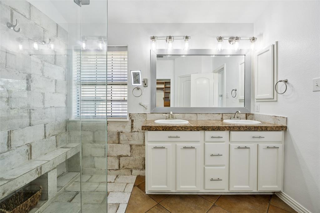 1503 Biltmore Lane Irving, TX 75063 - Photo 22 of 34 a bathroom with a granite countertop sink a mirror and a shower