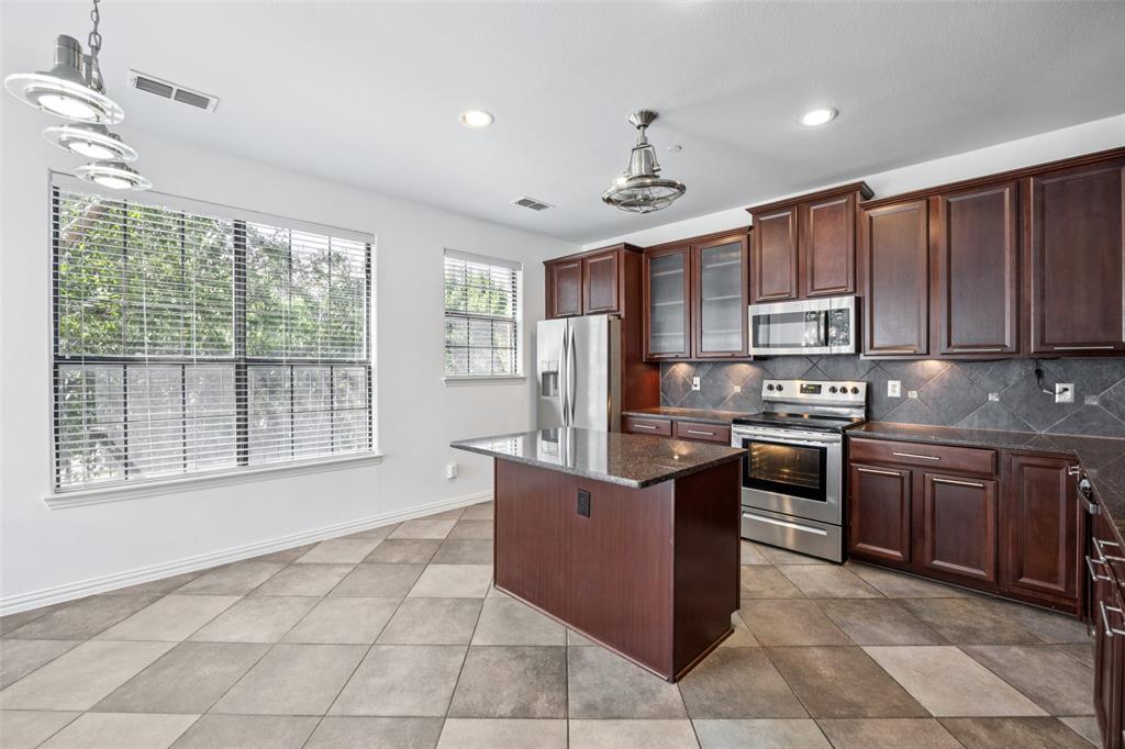 1503 Biltmore Lane Irving, TX 75063 - Photo 9 of 34 a kitchen with stainless steel appliances granite countertop a stove top oven a sink a counter top space cabinets and a window