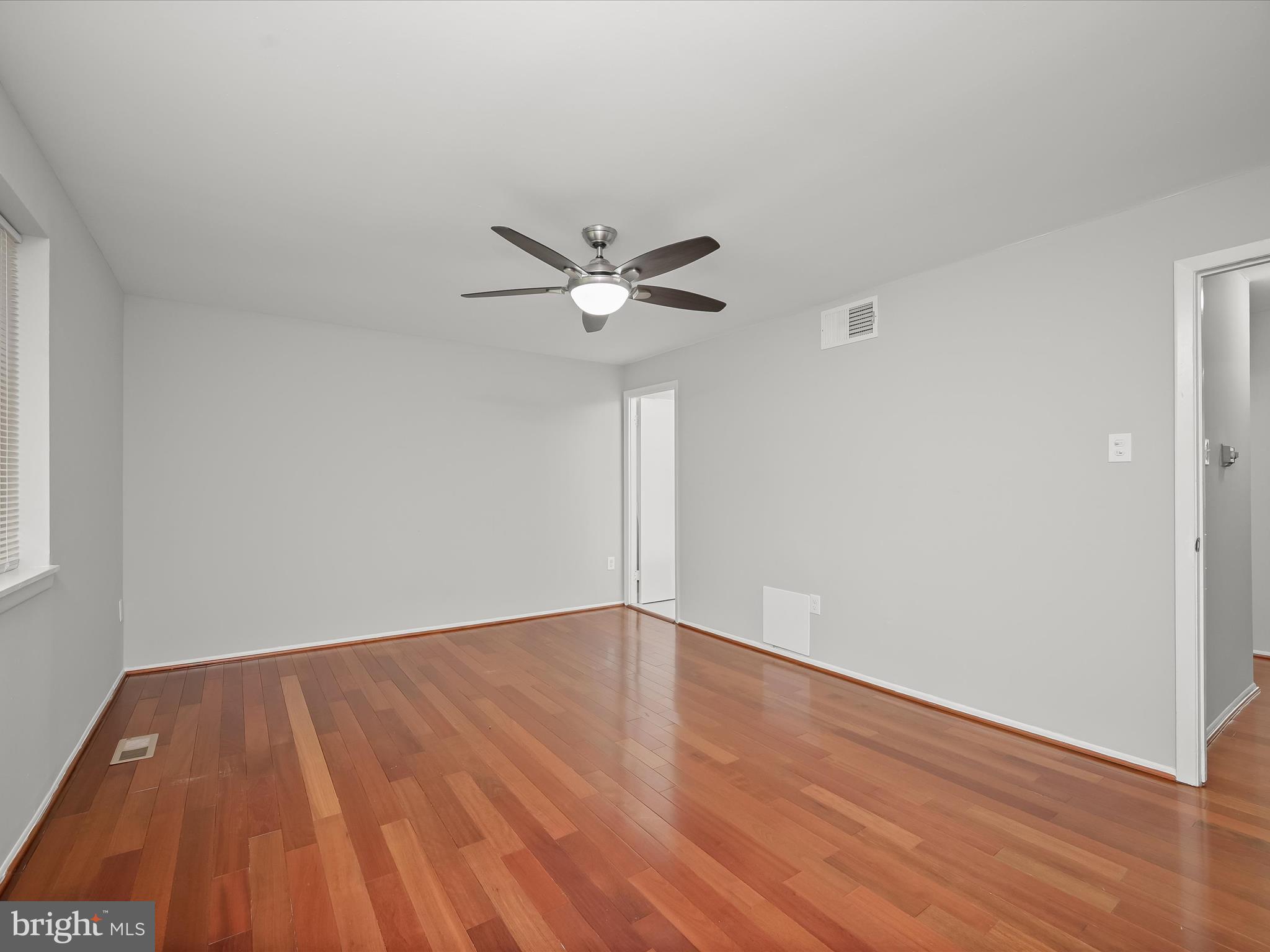 7106 Winter Rose Path Columbia, MD 21045 - Photo 19 of 50 a view of an empty room with wooden floor and a ceiling fan