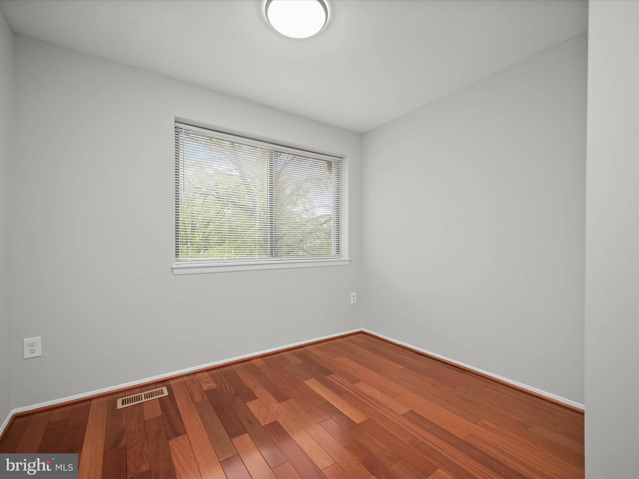 7106 Winter Rose Path Columbia, MD 21045 - Photo 22 of 50 a view of an empty room with wooden floor and a window