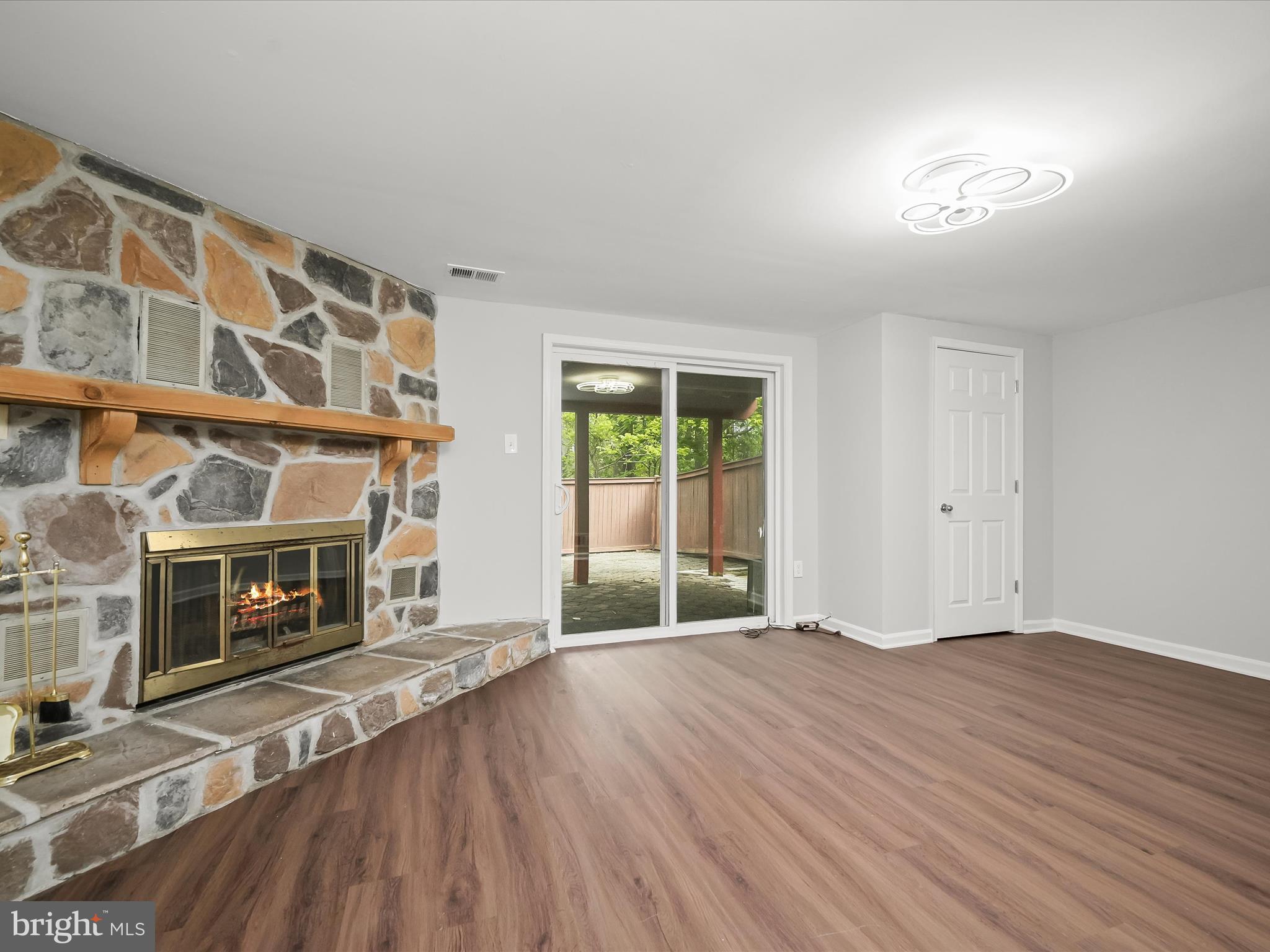 7106 Winter Rose Path Columbia, MD 21045 - Photo 29 of 50 a view of an empty room with wooden floor fireplace and a window