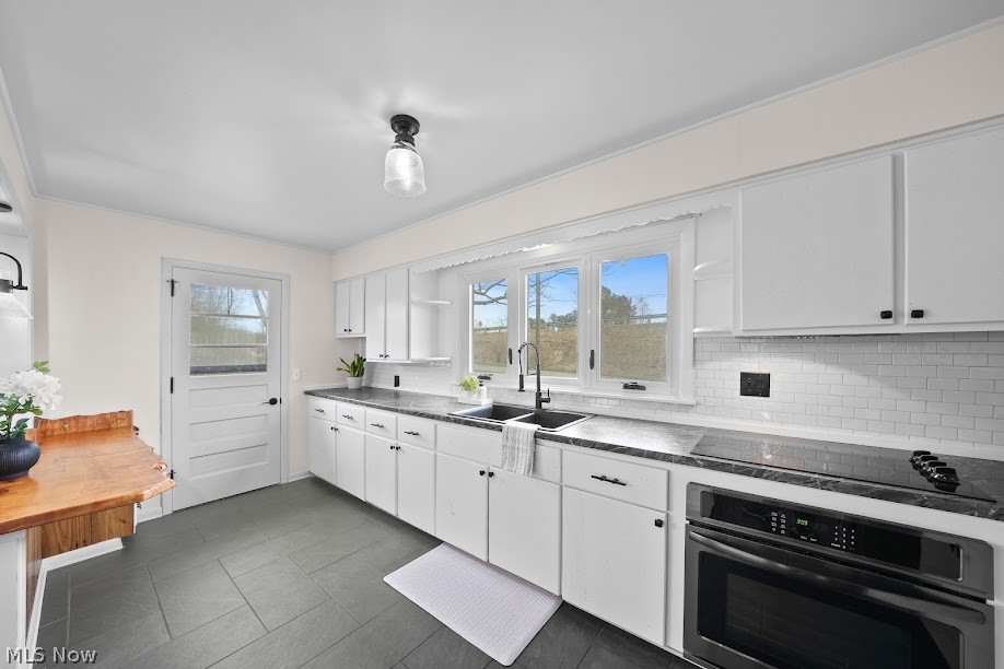 3235 Chapel Road Ashtabula, OH 44004 - Photo 3 of 13 Kitchen featuring white cabinetry, stainless steel oven, sink, and plenty of natural light