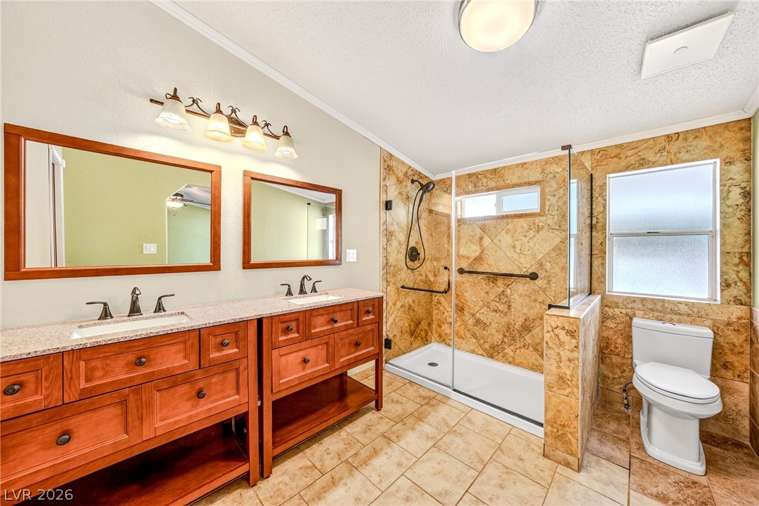 1831 West Horn Road Pahrump, NV 89048 - Photo 13 of 59 Dual vanities and a tiled walk-in shower elevate this contemporary bathroom space.