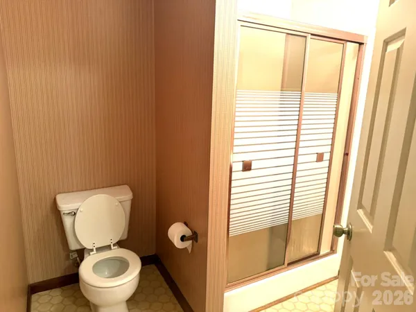 a bathroom with a toilet and a shower