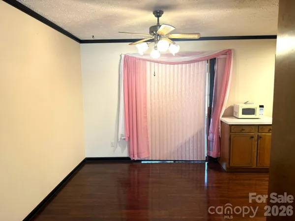 a view of a room with wooden floor and chandelier