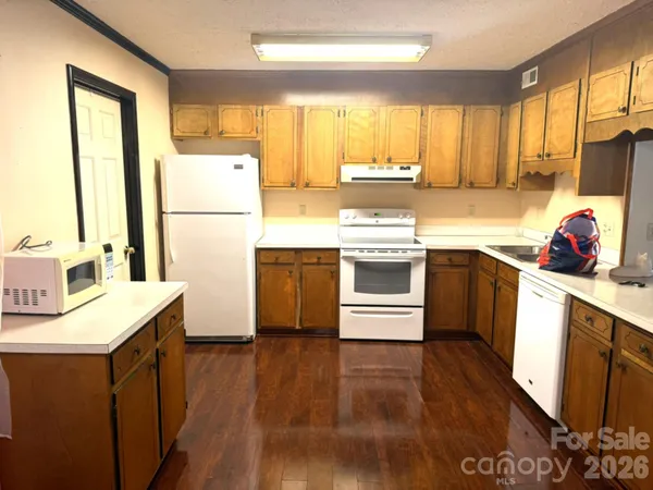 a kitchen with a sink a window a refrigerator and a stove top oven