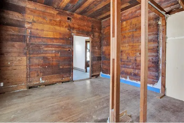 a view of an empty room with wooden floor