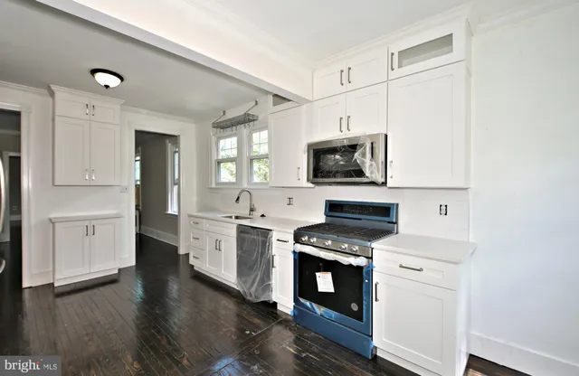 a view of a hallway with wooden floor and a chandelier
