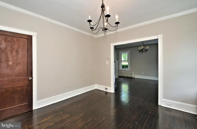 a view of a livingroom with wooden floor a fireplace and windows