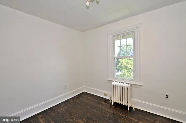 an empty room with fan and windows
