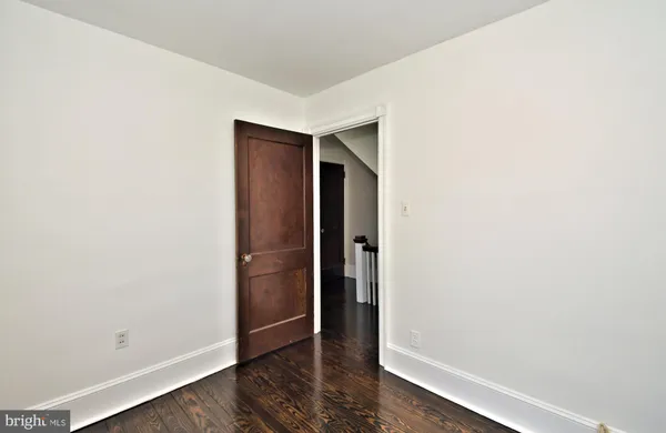 a view of a hallway with wooden floor and closet