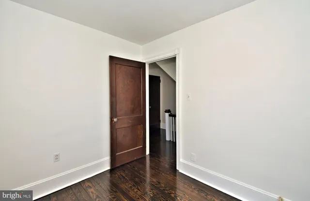 a view of a hallway with wooden floor and closet