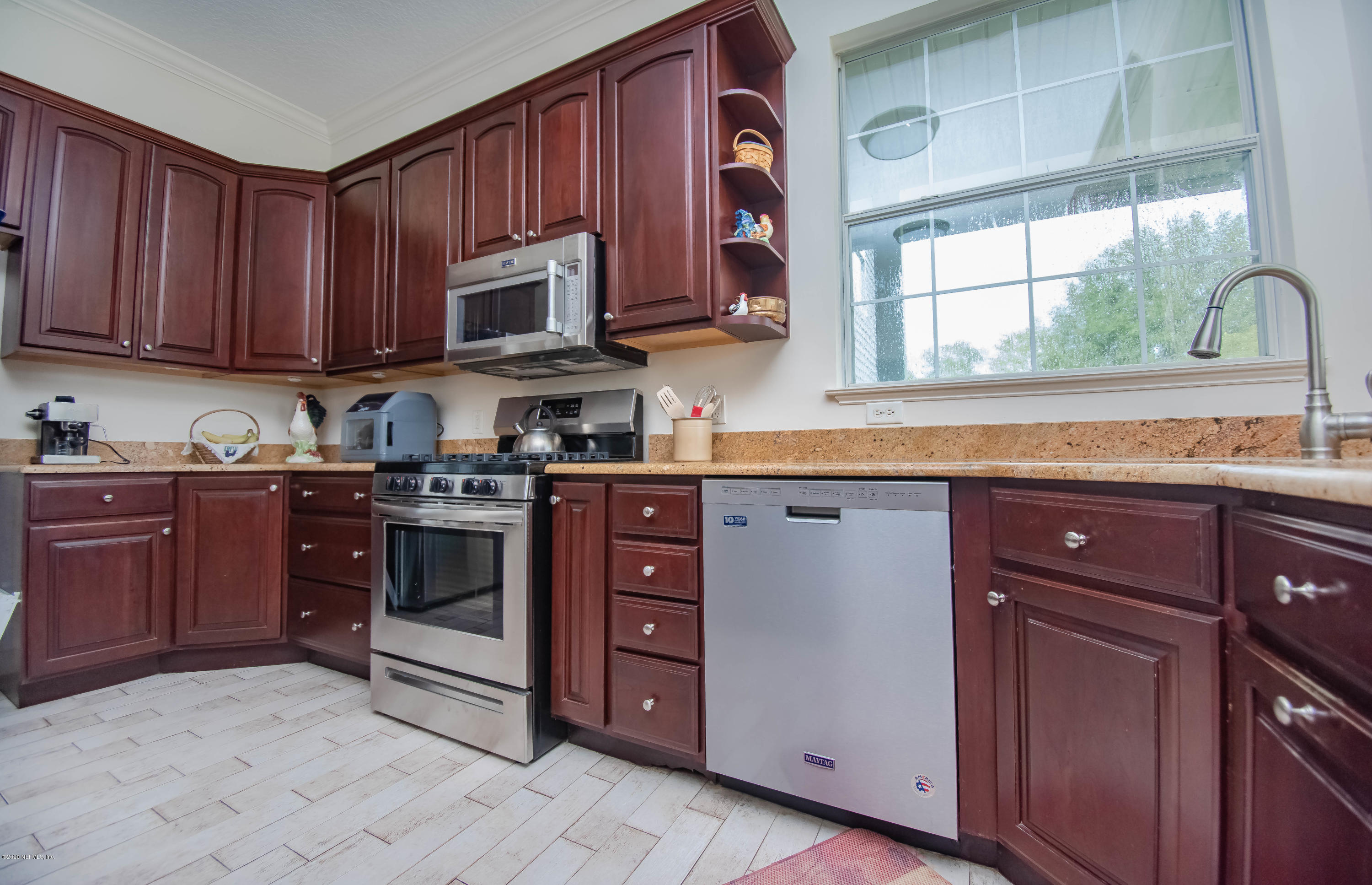8219 Mud Lake Road Macclenny, FL 32063 - Photo 14 of 63 a kitchen with stainless steel appliances granite countertop a stove a sink dishwasher and a microwave oven with cabinets