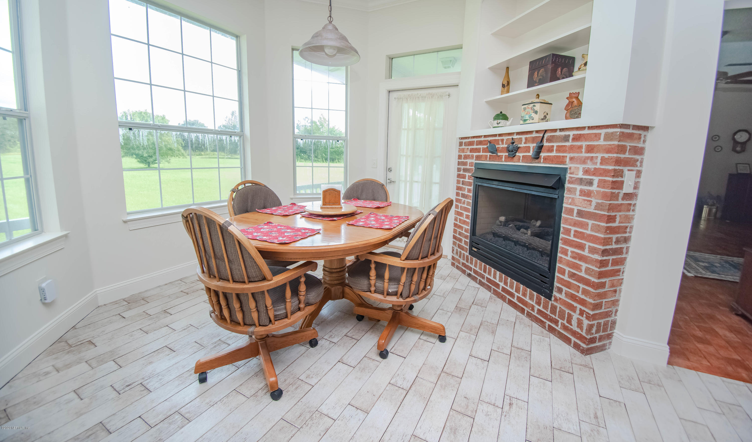 8219 Mud Lake Road Macclenny, FL 32063 - Photo 15 of 63 a dining room with furniture a fireplace and wooden floor
