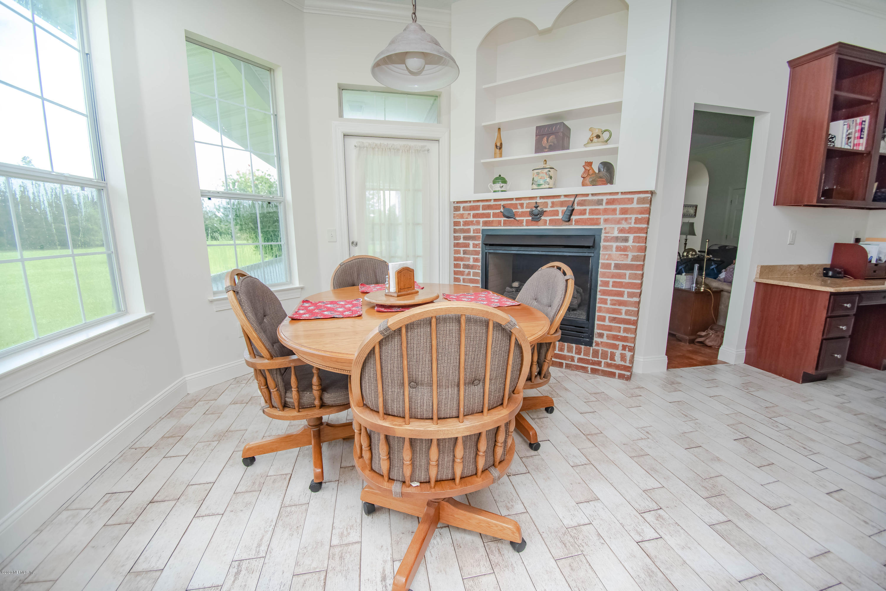 8219 Mud Lake Road Macclenny, FL 32063 - Photo 16 of 63 a dining room with furniture a fireplace and wooden floor
