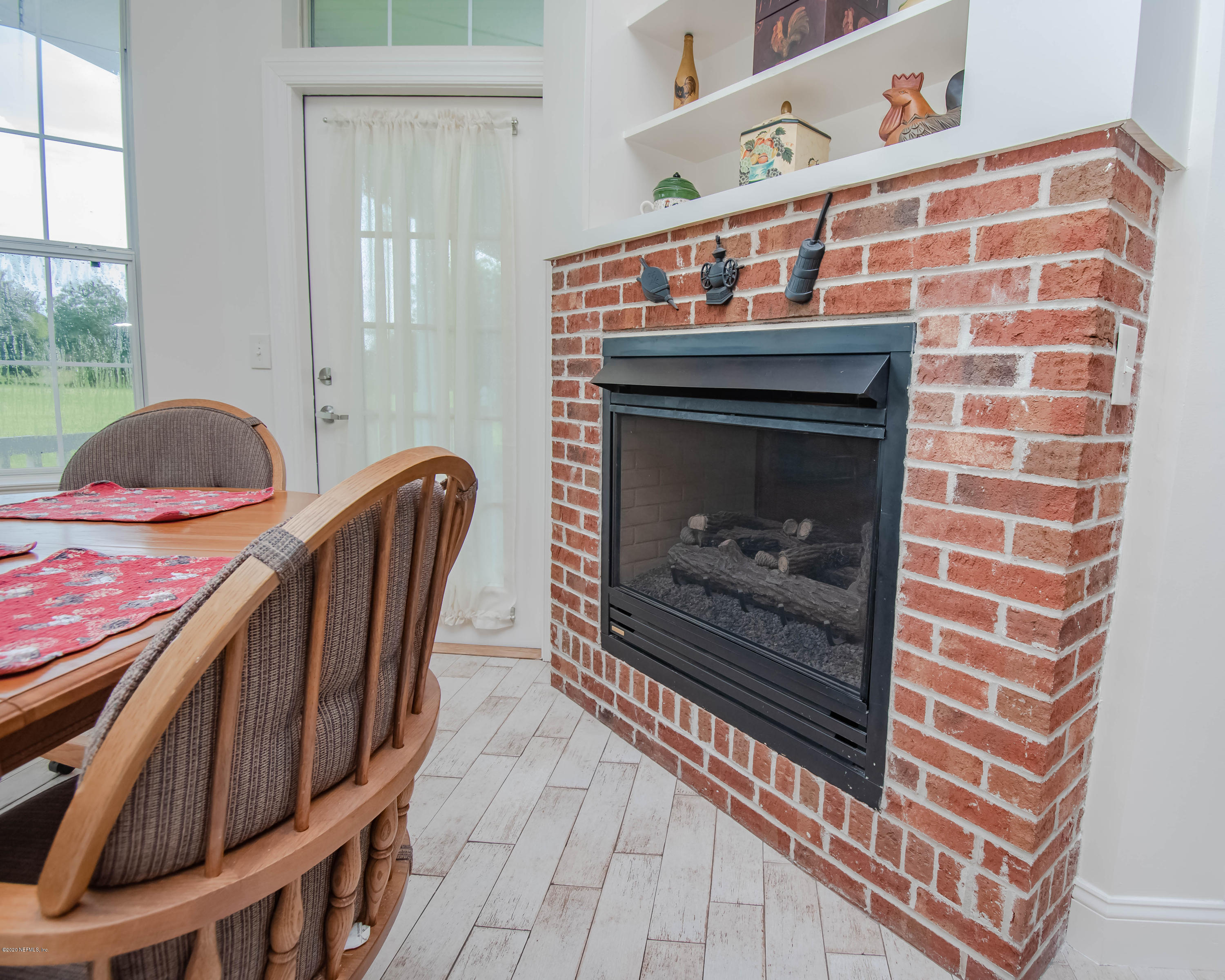 8219 Mud Lake Road Macclenny, FL 32063 - Photo 17 of 63 a fireplace with wooden floor in front of it