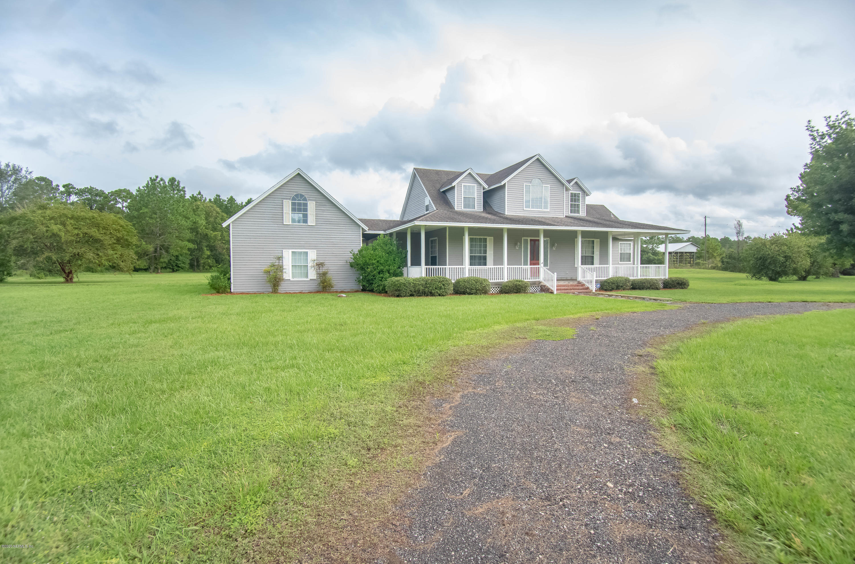 8219 Mud Lake Road Macclenny, FL 32063 - Photo 4 of 63 a front view of a house with a yard and potted plants