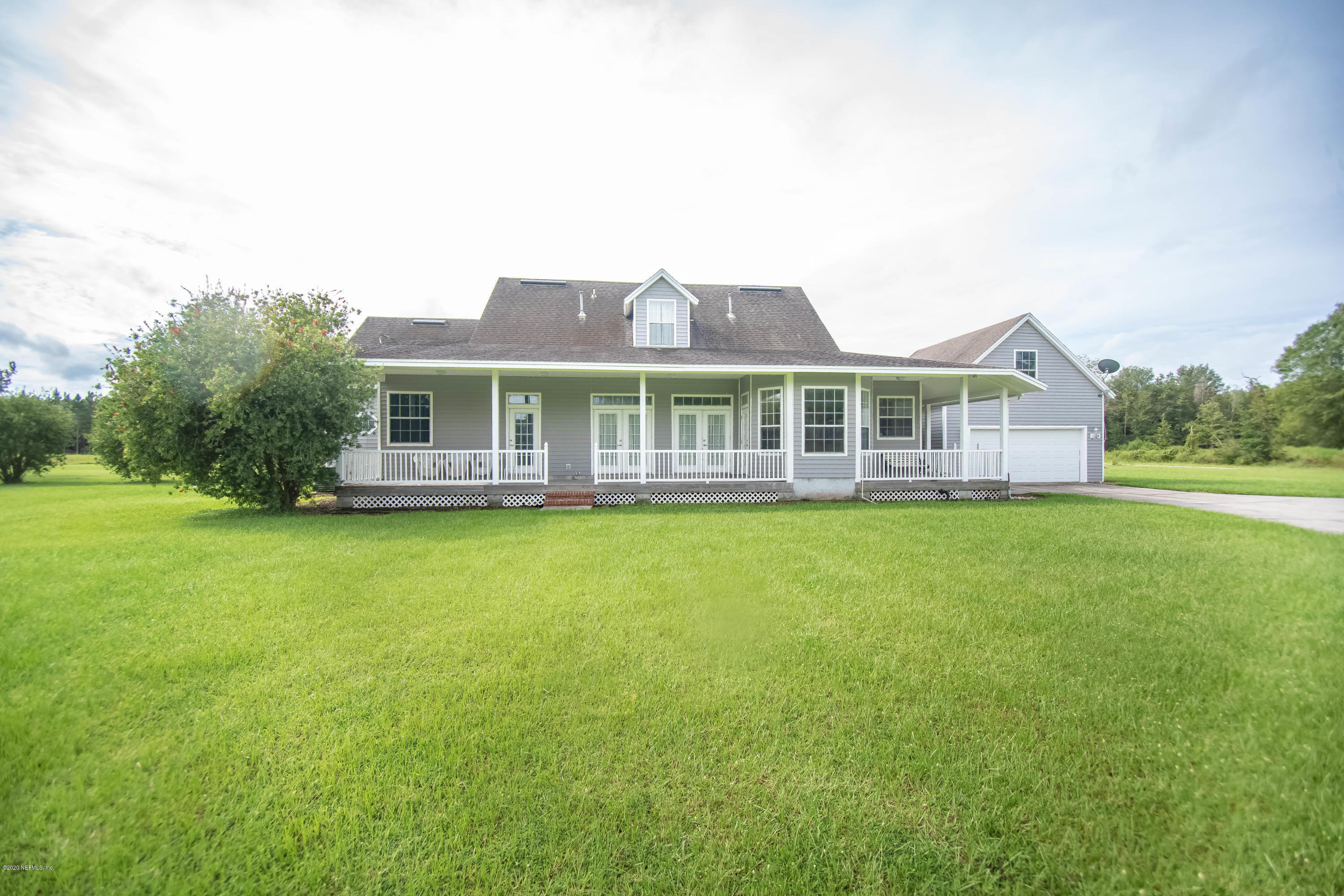 8219 Mud Lake Road Macclenny, FL 32063 - Photo 42 of 63 a front view of a house with a garden and lake view