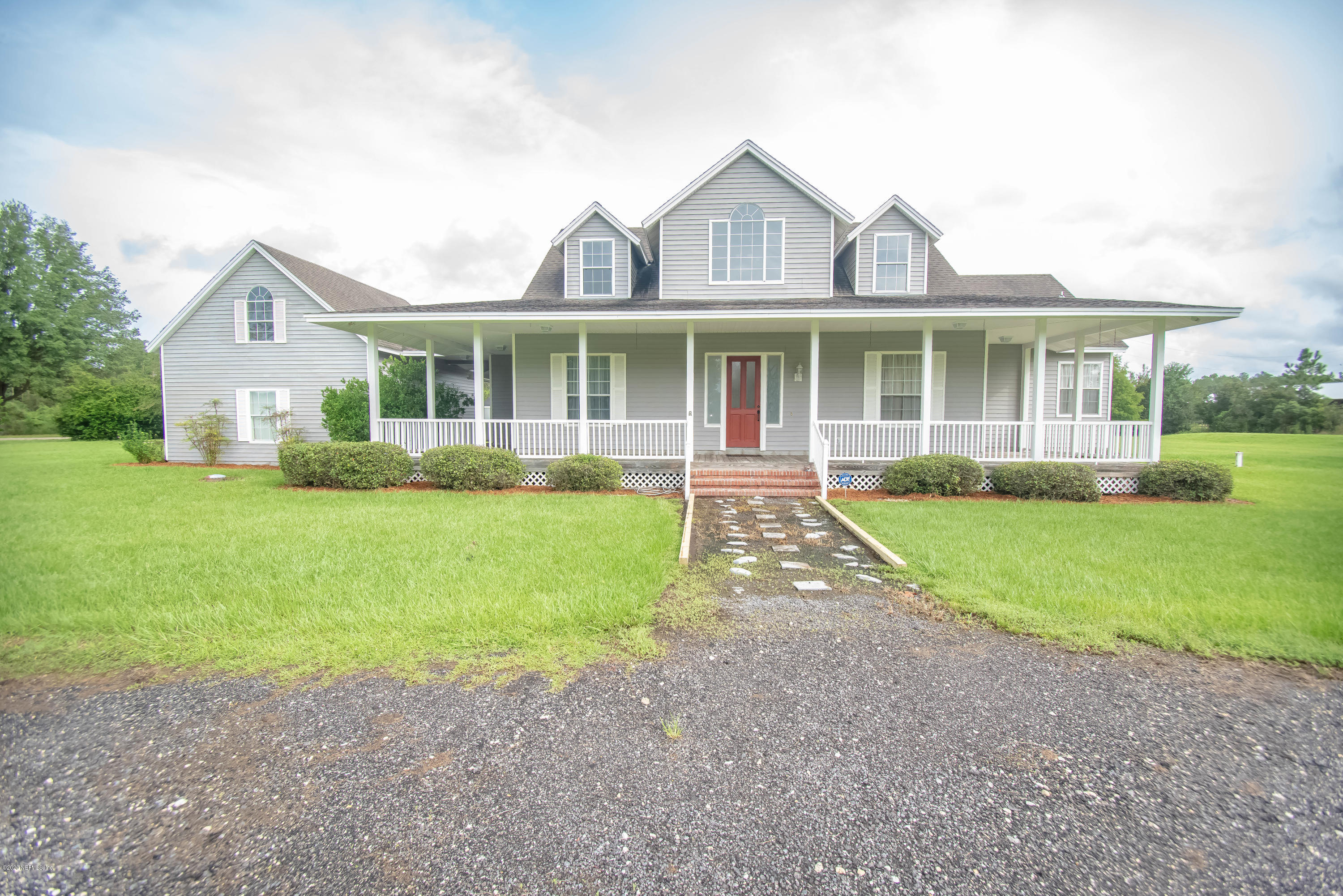8219 Mud Lake Road Macclenny, FL 32063 - Photo 61 of 63 a front view of a house with a yard and potted plants