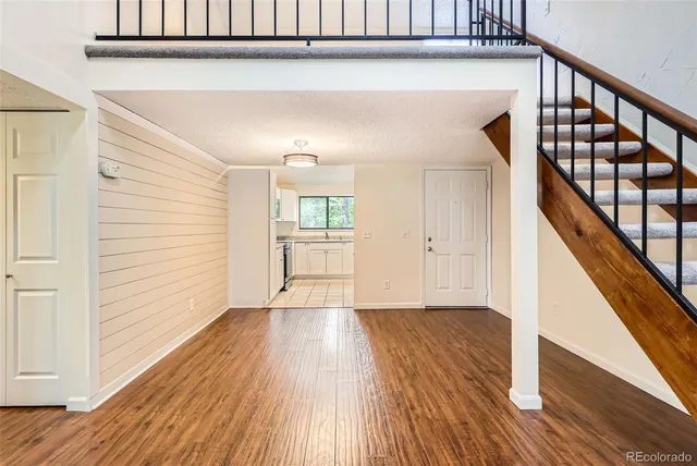 a view of a hallway with wooden floor and staircase