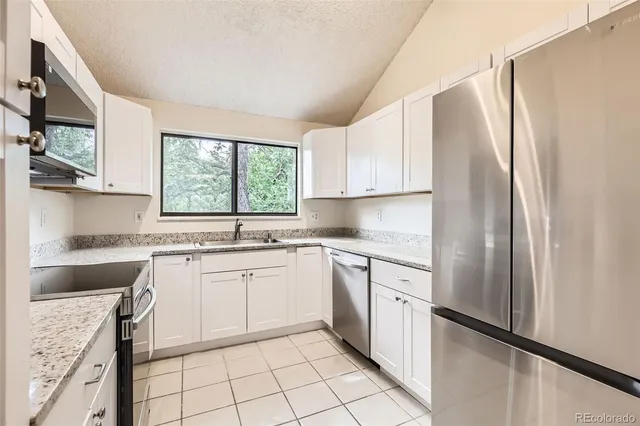 a kitchen with white cabinets and white appliances