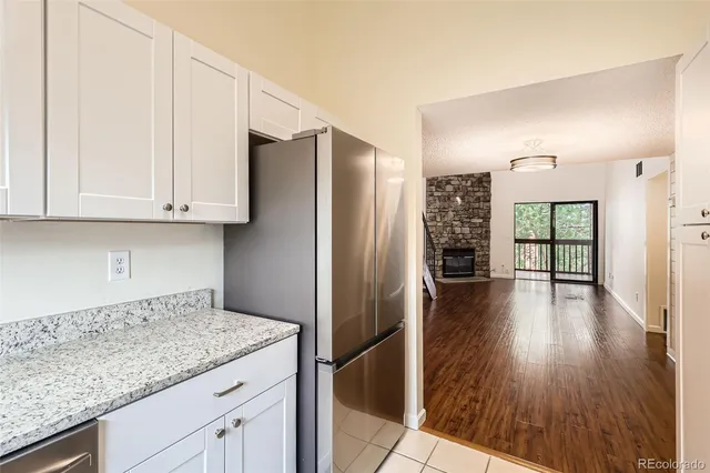 a kitchen with granite countertop a refrigerator and wooden floor