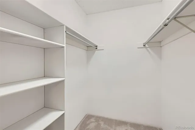 a view of walk in closet with empty racks
