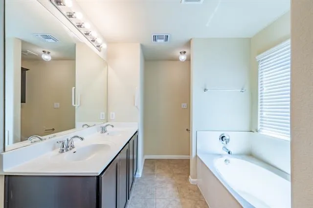 a bathroom with a bathtub sink and mirror