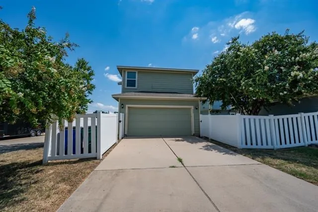 a view of backyard and wooden fence