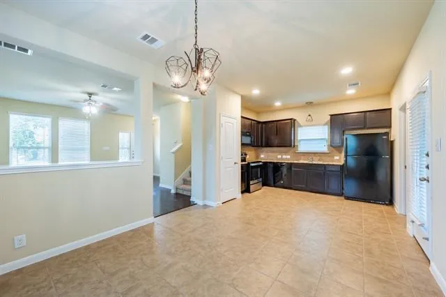 a large kitchen with a refrigerator a stove and a sink
