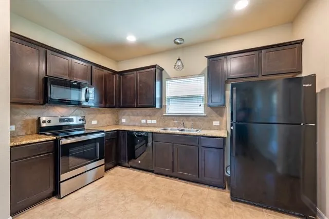 a kitchen with stainless steel appliances granite countertop a refrigerator stove a sink and dishwasher