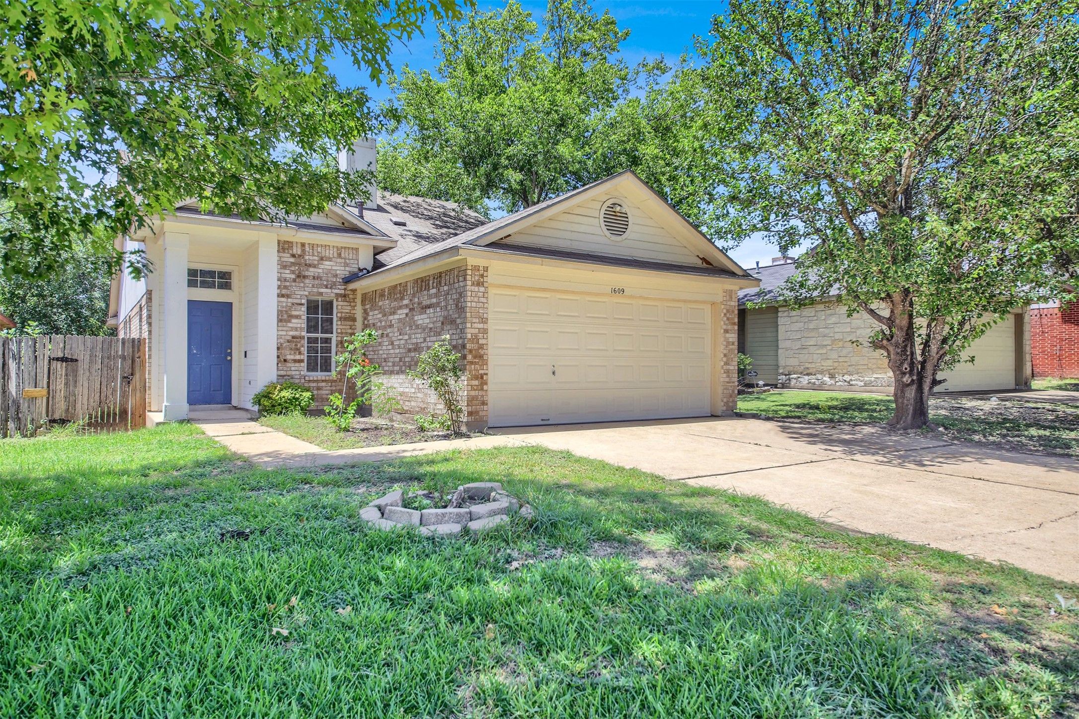 1609 Harness Raceway Street Pflugerville, TX 78660 - Photo 1 of 32 A charming single-story residence with a two-car garage and a welcoming blue front door.