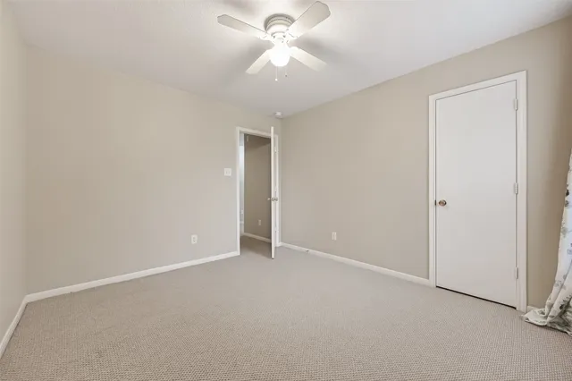 an empty room with closet and a chandelier fan