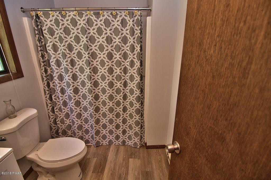 2412 Crest View Road Lake Ariel, PA 18436 - Photo 19 of 50 a bathroom with a toilet and a shower curtain