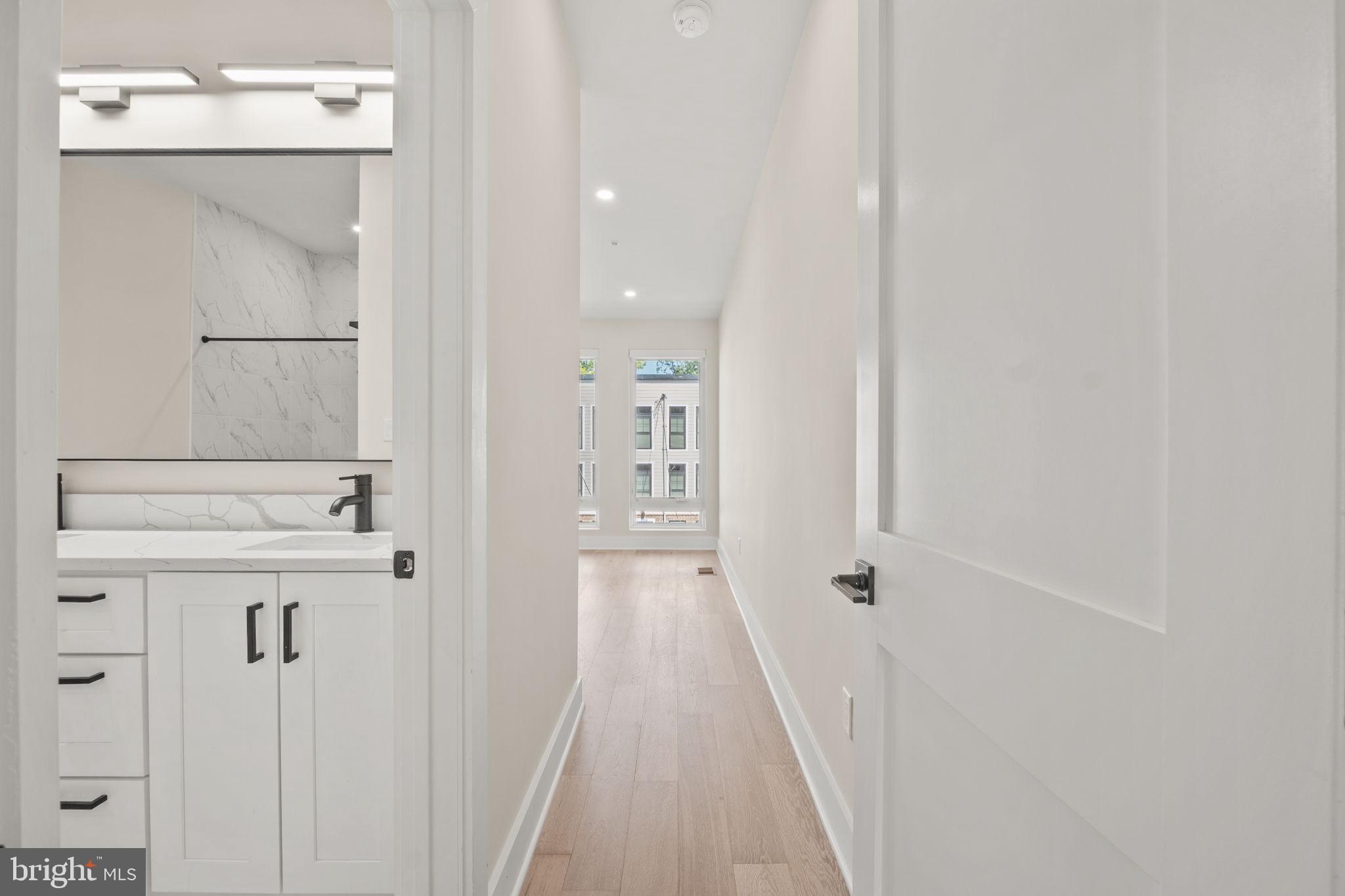 1923 Capitol Avenue Northeast, Unit 2 Washington, DC 20002 - Photo 22 of 32 a bathroom with a sink a mirror and shower