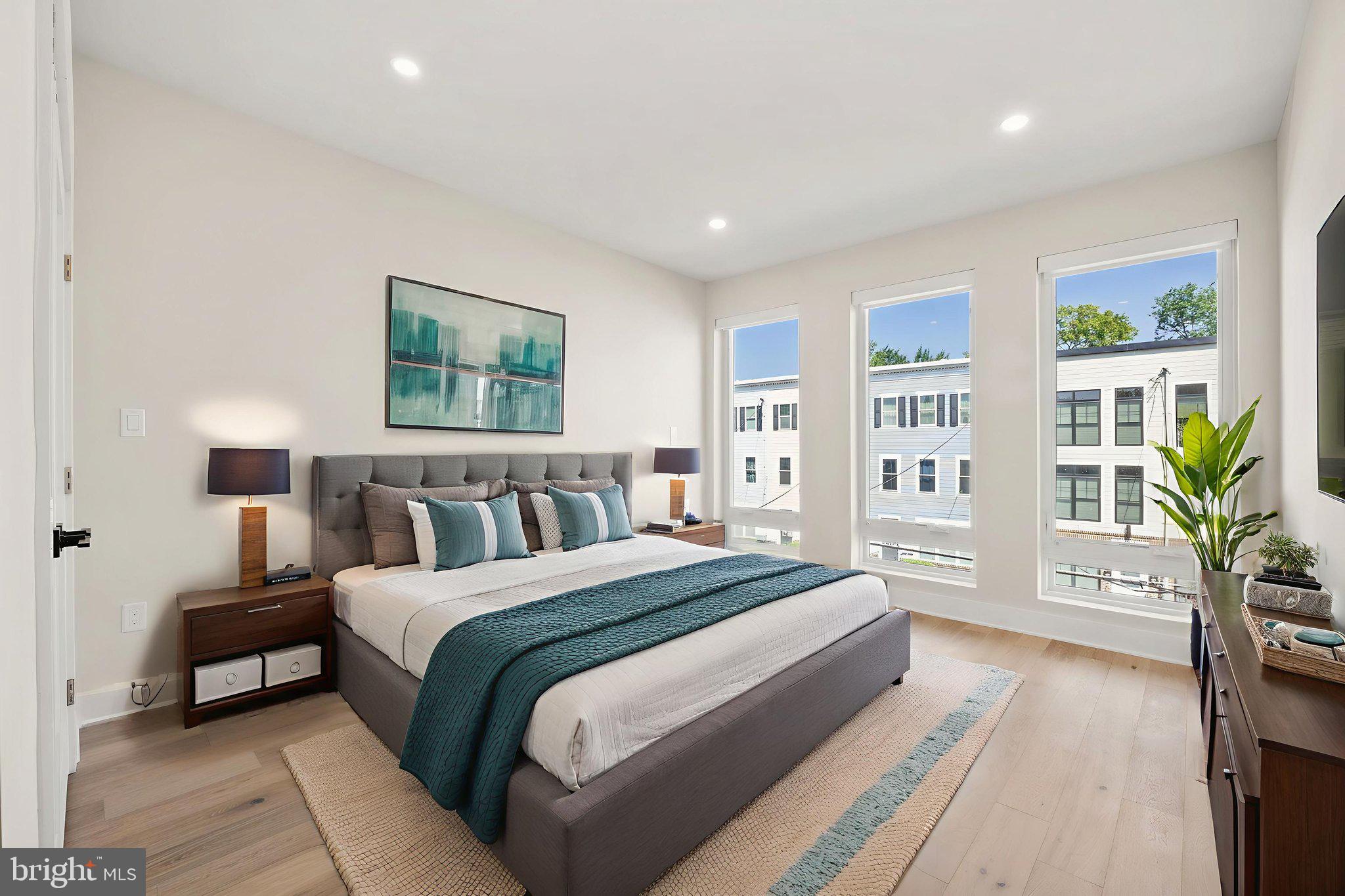 1923 Capitol Avenue Northeast, Unit 2 Washington, DC 20002 - Photo 24 of 32 a spacious bedroom with a large bed a potted plant and a window