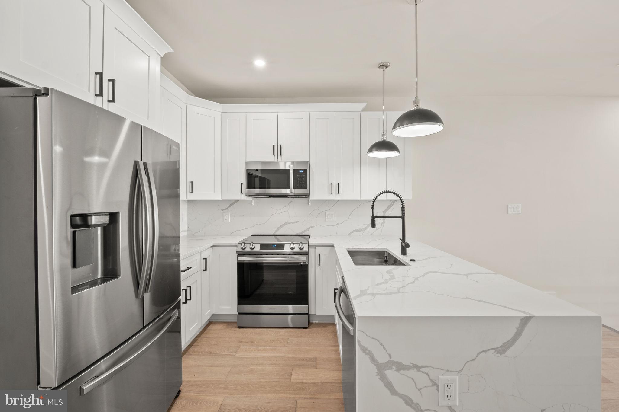 1923 Capitol Avenue Northeast, Unit 2 Washington, DC 20002 - Photo 9 of 32 a kitchen with stainless steel appliances a refrigerator sink and microwave