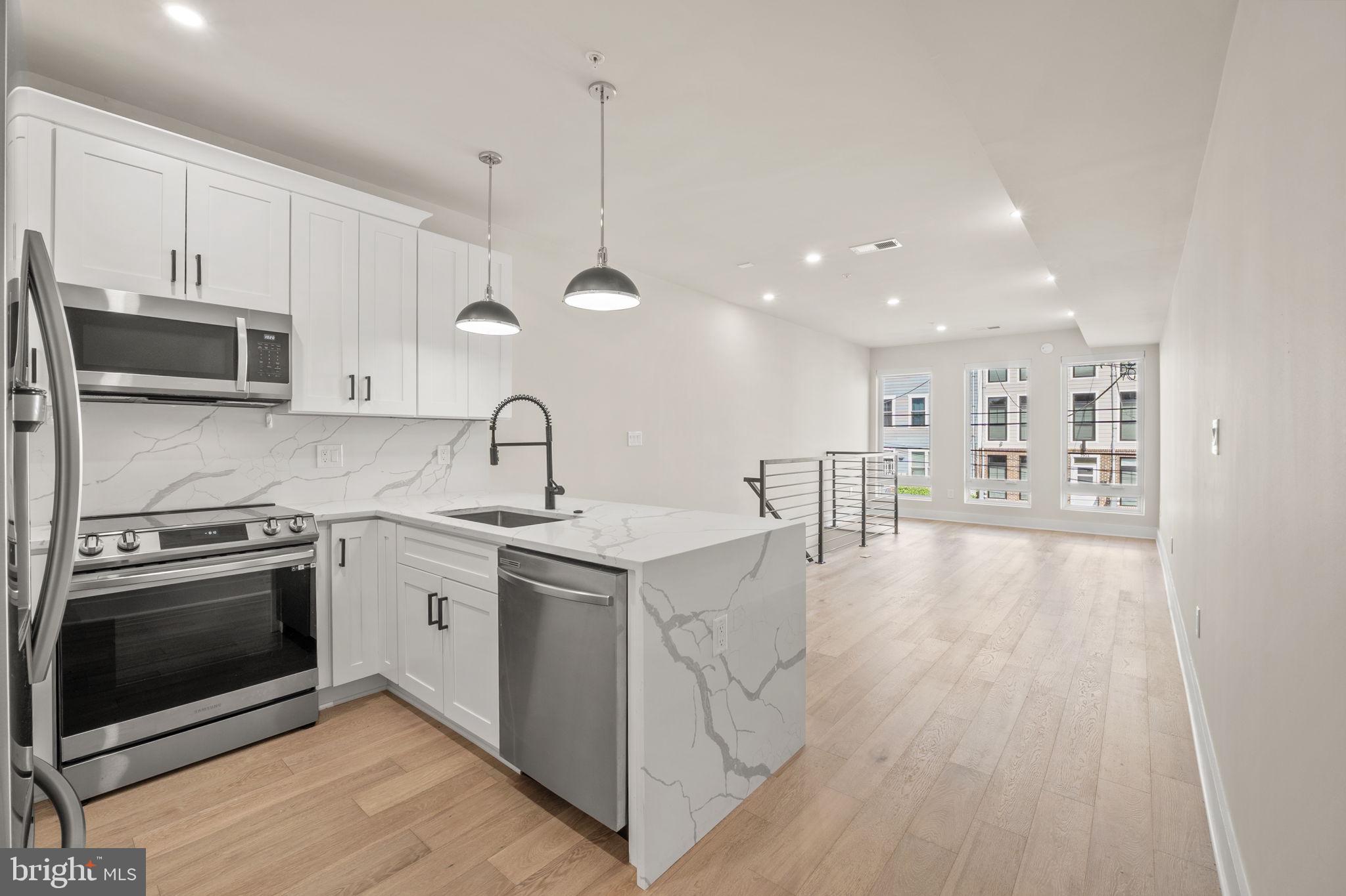 1923 Capitol Avenue Northeast, Unit 2 Washington, DC 20002 - Photo 10 of 32 a kitchen with stainless steel appliances granite countertop a oven a stove and a wooden floors