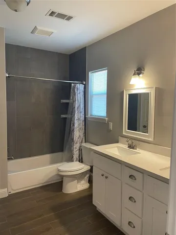 a bathroom with a double vanity sink toilet and shower