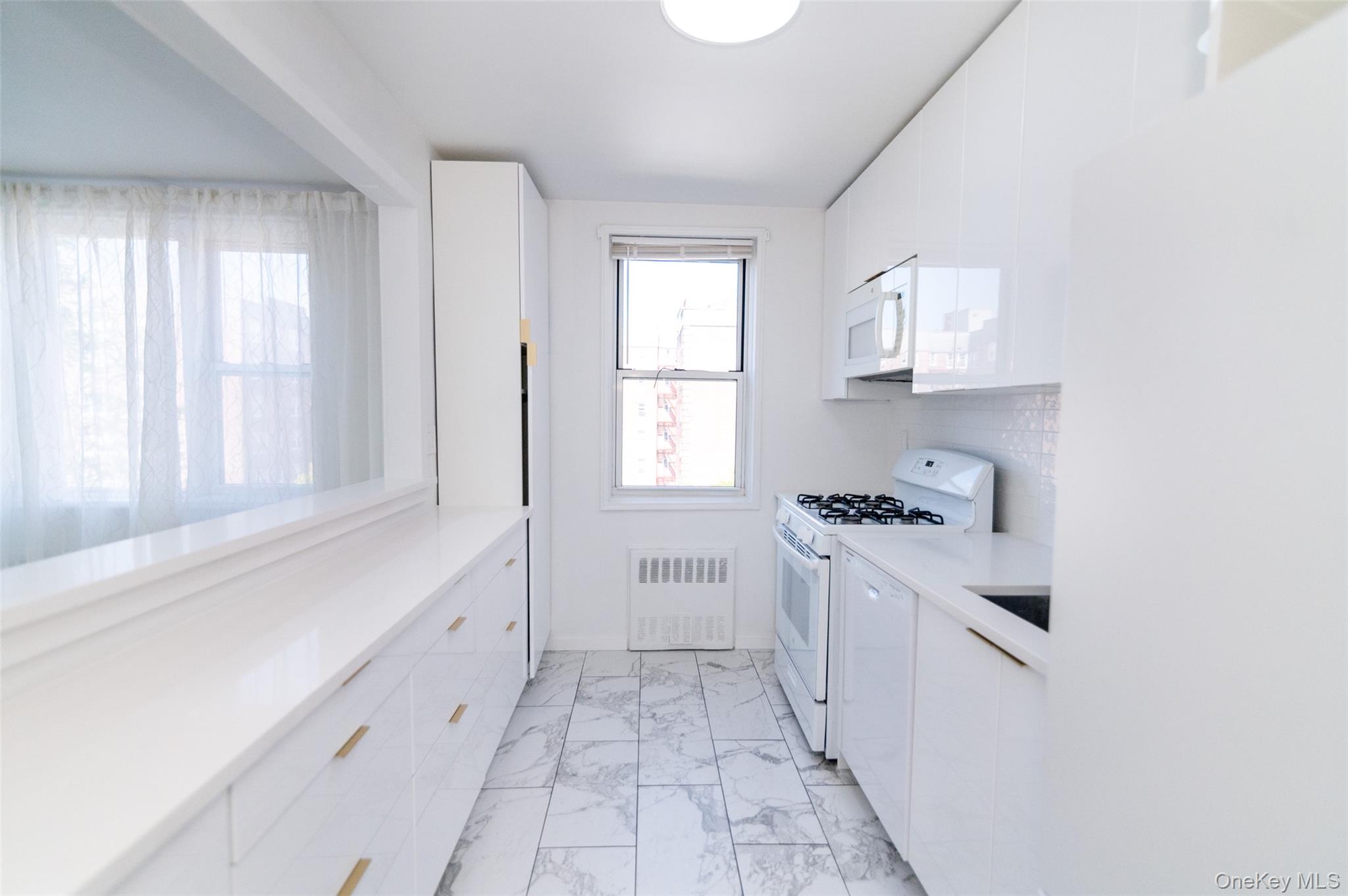 1 Sadore Lane, Unit 5A Yonkers, NY 10710 - Photo 6 of 23 a kitchen with white cabinets and a stove
