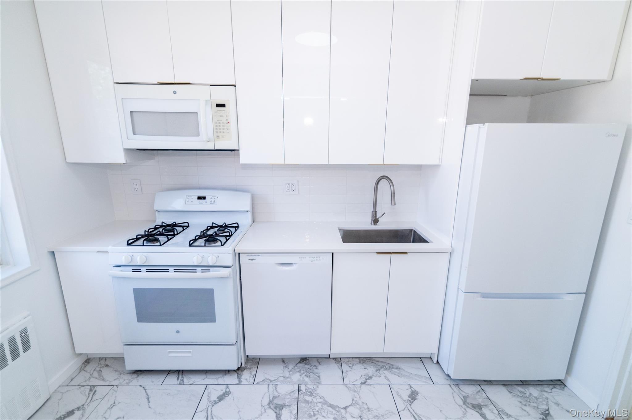 1 Sadore Lane, Unit 5A Yonkers, NY 10710 - Photo 9 of 23 a kitchen with white cabinets and white appliances