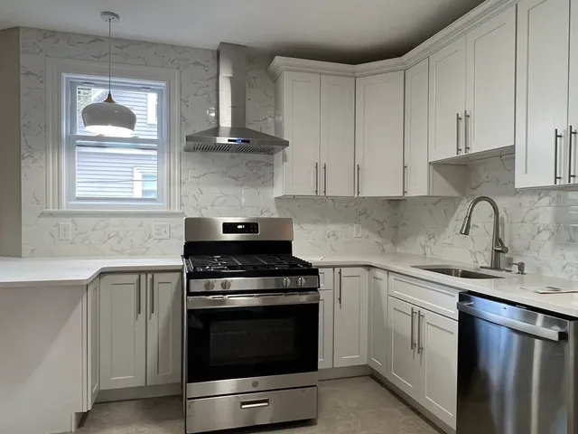 a kitchen with cabinets stainless steel appliances and a sink