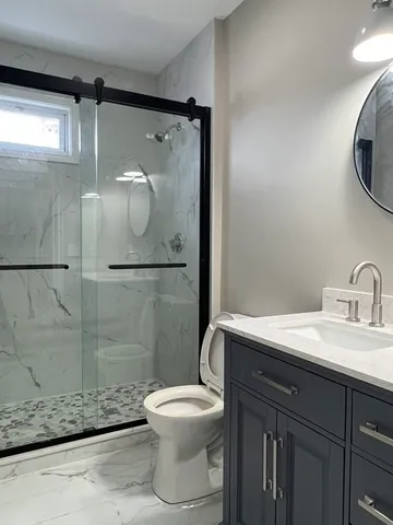 a bathroom with a sink a toilet and shower