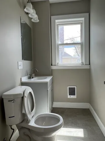 a bathroom with a toilet mirror and a sink